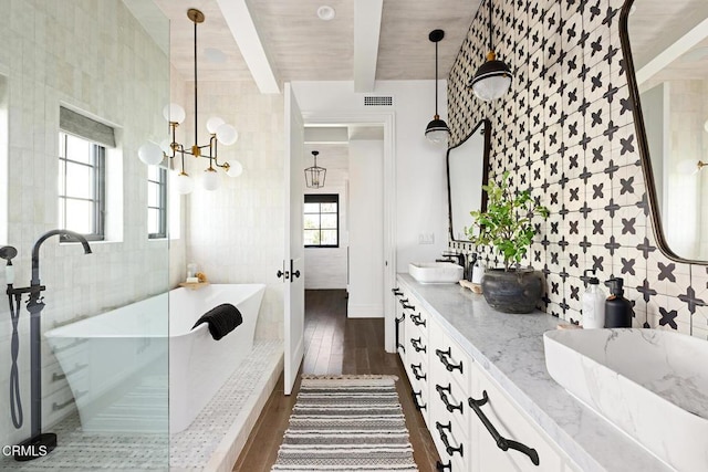 bathroom featuring tile walls, wood finished floors, beam ceiling, a sink, and a freestanding bath