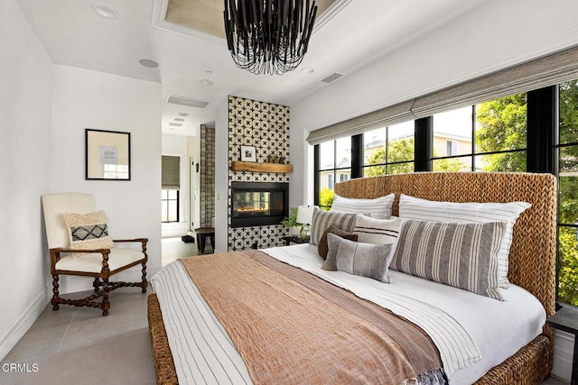 bedroom with light tile patterned floors, a tile fireplace, a chandelier, and visible vents