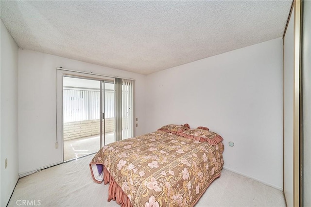 carpeted bedroom featuring access to exterior and a textured ceiling