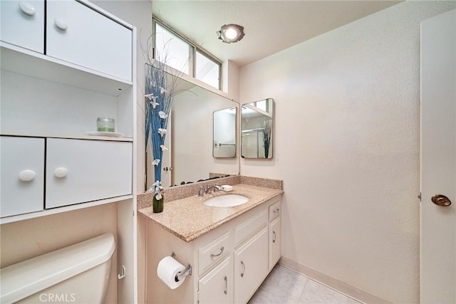 bathroom featuring toilet, tile patterned flooring, and vanity