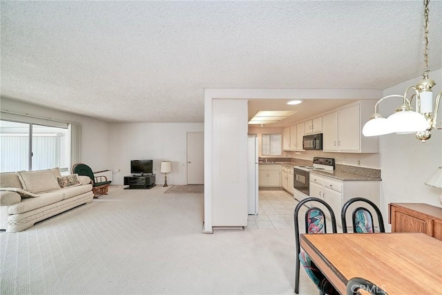 kitchen with black microwave, a textured ceiling, open floor plan, electric stove, and white cabinets