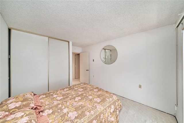 unfurnished bedroom featuring a closet, light colored carpet, and a textured ceiling