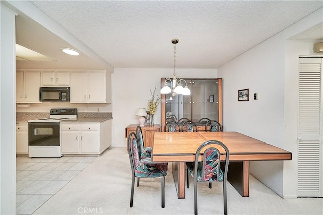 dining space with light tile patterned flooring, a textured ceiling, and a notable chandelier
