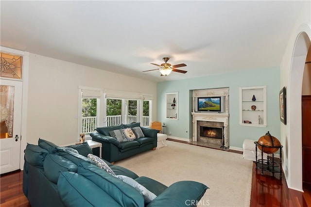 27601 Cedarwood Dr, Lake Arrowhead, CA 92352 - living area with dark wood finished floors, built in features, baseboards, ceiling fan, and a high end fireplace
