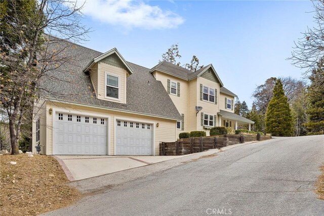 27601 Cedarwood Dr, Lake Arrowhead, CA 92352 - view of front of house featuring concrete driveway, a shingled roof, and an attached garage
