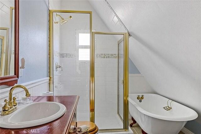 27601 Cedarwood Dr, Lake Arrowhead, CA 92352 - full bath featuring a wainscoted wall, vanity, vaulted ceiling, a shower stall, and a freestanding tub