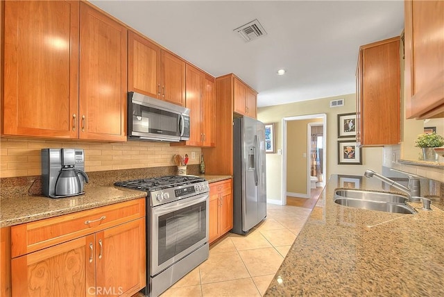 kitchen featuring decorative backsplash, a sink, stainless steel appliances, and visible vents