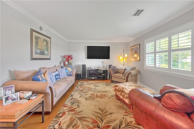 living room with visible vents, light wood-style flooring, and ornamental molding