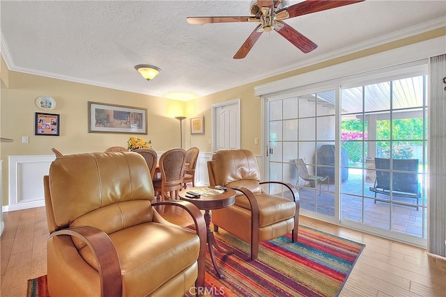 interior space with a textured ceiling, crown molding, a ceiling fan, and hardwood / wood-style floors