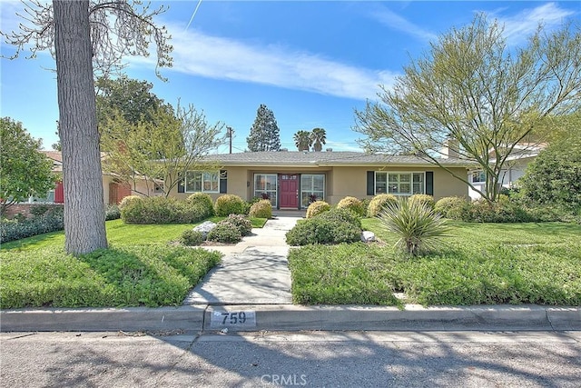 ranch-style home with stucco siding and a front yard