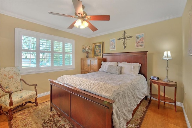 bedroom featuring light wood-style flooring, crown molding, baseboards, and ceiling fan