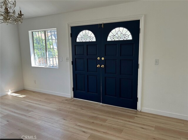 3391 Scarboro St, Los Angeles, CA 90065 - entrance foyer featuring a chandelier, light wood-style floors, and baseboards