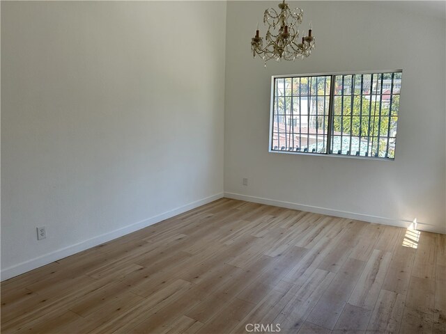 3391 Scarboro St, Los Angeles, CA 90065 - empty room with a chandelier, light wood finished floors, and baseboards