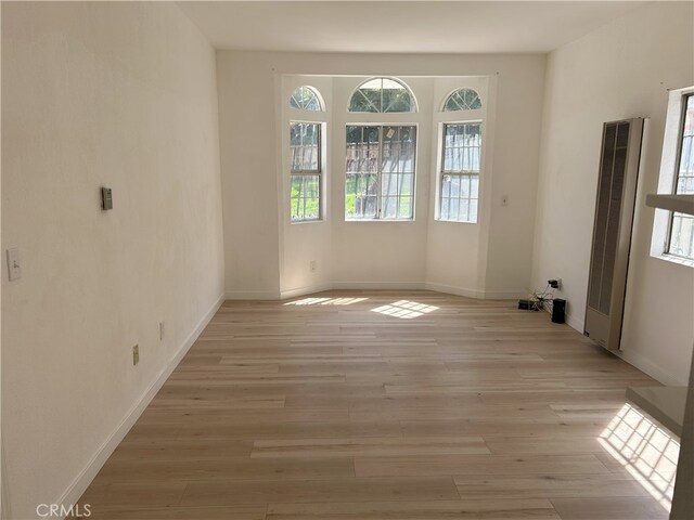 3391 Scarboro St, Los Angeles, CA 90065 - empty room with a heating unit, light wood-style floors, and baseboards