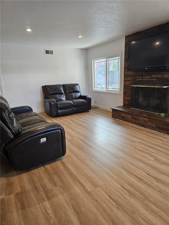 1043 W Orange Rd, Santa Ana, CA 92706 - living room with wood finished floors, baseboards, a large fireplace, a textured ceiling, and recessed lighting
