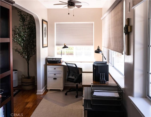 office featuring wood finished floors, ceiling fan, and a healthy amount of sunlight
