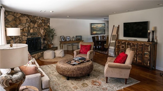 living room with visible vents, wood finished floors, and a fireplace