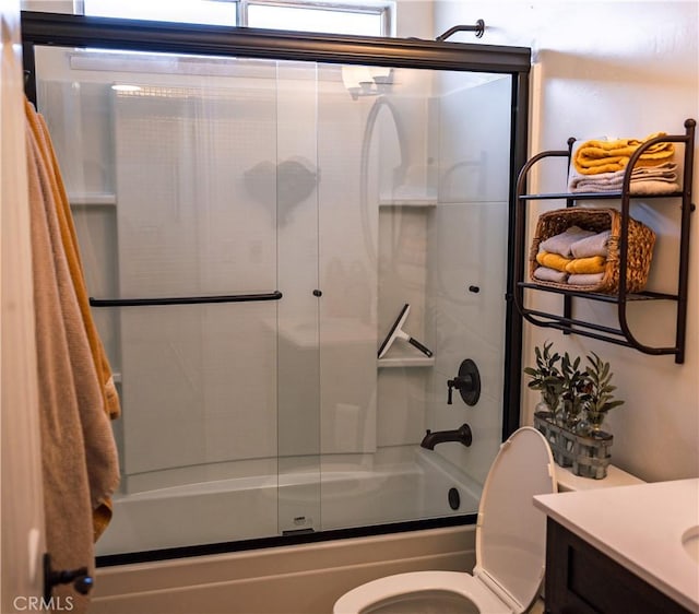 bathroom with toilet, vanity, and shower / bath combination with glass door