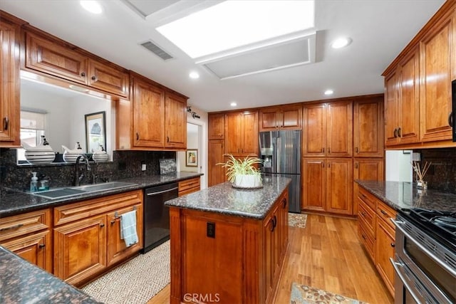 1040 Par Ave, Paso Robles, CA 93446 - kitchen featuring appliances with stainless steel finishes, a sink, brown cabinets, decorative backsplash, and a center island