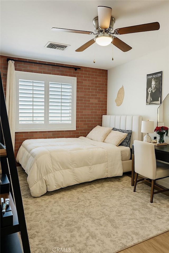 891 Hedges Dr, Corona, CA 92878 - bedroom featuring brick wall, wood finished floors, a ceiling fan, and visible vents