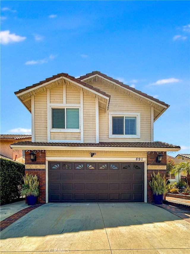 891 Hedges Dr, Corona, CA 92878 - view of front of house featuring an attached garage, driveway, and brick siding