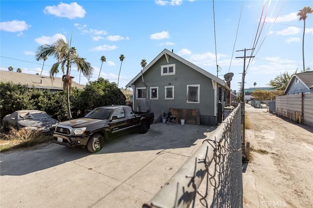 view of side of home with driveway and fence