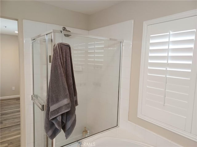 bathroom with wood finished floors and a stall shower