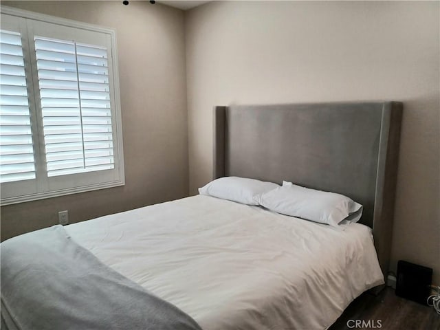bedroom with dark wood-type flooring
