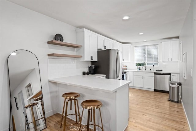 1727 W 59th Pl, Los Angeles, CA 90047 - kitchen featuring appliances with stainless steel finishes, open shelves, a peninsula, decorative backsplash, and recessed lighting