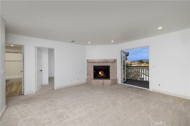 unfurnished living room with visible vents, baseboards, a tiled fireplace, carpet, and recessed lighting