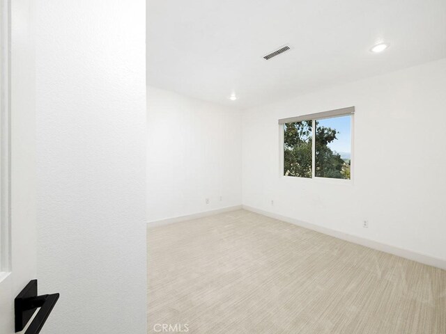carpeted empty room featuring visible vents, baseboards, and recessed lighting