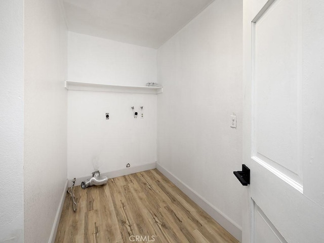 clothes washing area featuring laundry area, hookup for an electric dryer, washer hookup, light wood finished floors, and baseboards