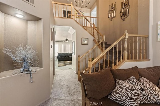 19189 San Jacinto Way, Apple Valley, CA 92308 - carpeted living room featuring stairway, visible vents, a towering ceiling, and ceiling fan with notable chandelier