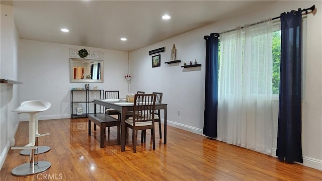 dining space with light wood finished floors, baseboards, and recessed lighting