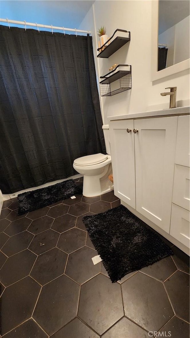 full bathroom with a shower with curtain, tile patterned floors, vanity, and toilet