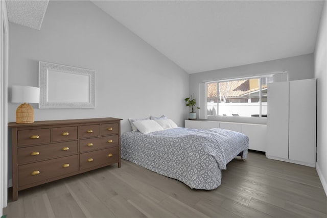 bedroom featuring light wood-type flooring and lofted ceiling