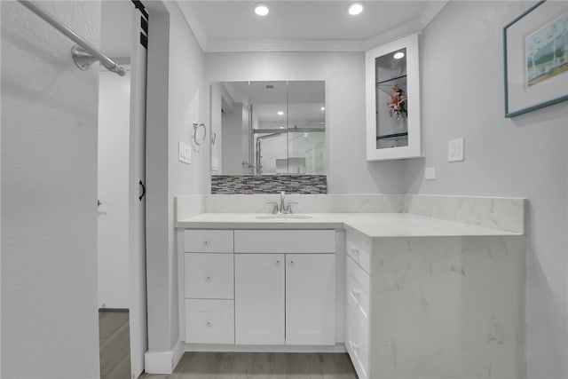 full bathroom featuring crown molding, a shower stall, vanity, recessed lighting, and wood finished floors