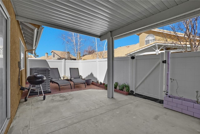 view of patio with cooling unit, a fenced backyard, and a gate