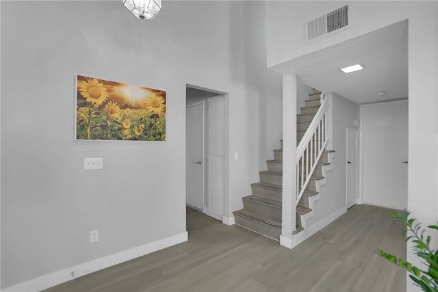 interior space featuring stairs, visible vents, baseboards, and wood finished floors