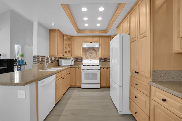 kitchen with white appliances, recessed lighting, under cabinet range hood, a sink, and light brown cabinets