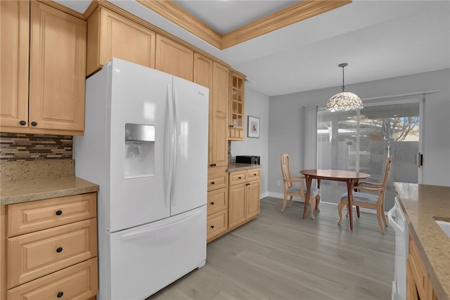 kitchen featuring white appliances, light wood-style flooring, a tray ceiling, light brown cabinetry, and backsplash