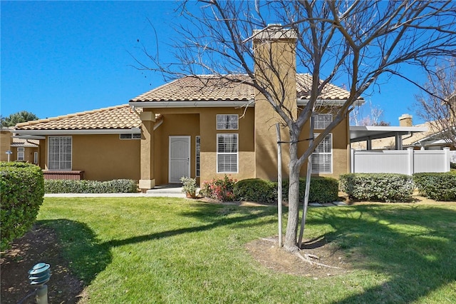 mediterranean / spanish home with a tiled roof, stucco siding, a front yard, fence, and a chimney