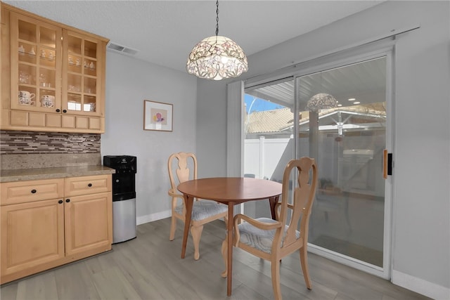 dining room with visible vents, baseboards, light wood-type flooring, and a notable chandelier