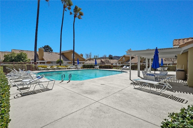 community pool with fence and a patio