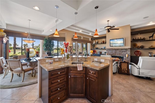 9 Via Haciendas, Rancho Mirage, CA 92270 - kitchen with a fireplace, open floor plan, a ceiling fan, dark brown cabinets, and a tray ceiling