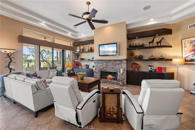 9 Via Haciendas, Rancho Mirage, CA 92270 - living room with a tray ceiling, visible vents, a stone fireplace, and a ceiling fan