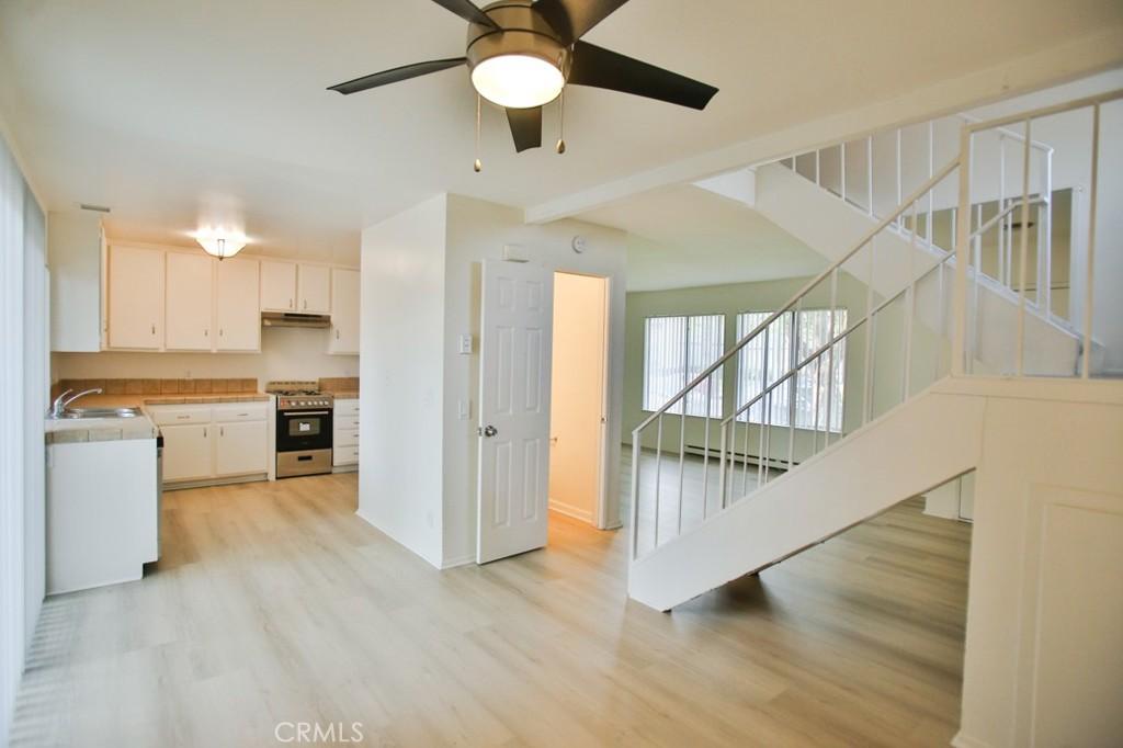 240 Carriage Dr Unit D, Santa Ana, CA 92707 - kitchen featuring a sink, white cabinets, stainless steel gas stove, and light wood-style floors