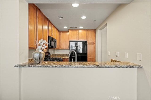 28476 Herrera St, Valencia, CA 91354 - kitchen featuring black appliances, a peninsula, stone countertops, recessed lighting, and a sink