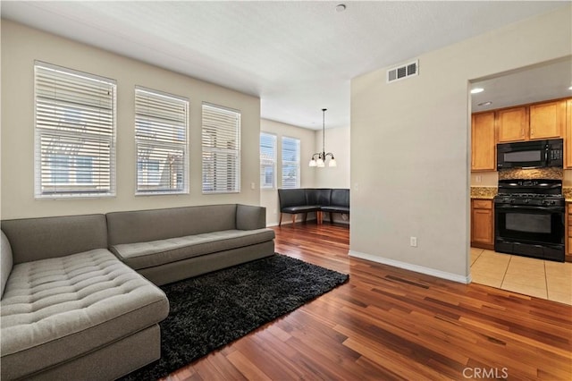 28476 Herrera St, Valencia, CA 91354 - living area with light wood-type flooring, baseboards, and a chandelier