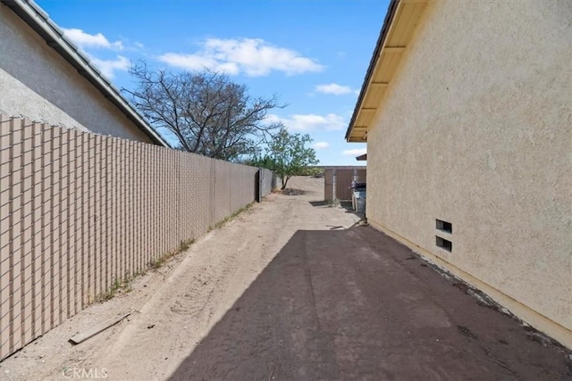 12963 Birch Glen Ct, Victorville, CA 92392 - view of side of home featuring stucco siding, crawl space, and a patio area